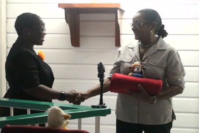 Ms. Jeanette Grell-Hull presents blankets to Project Officer for School Libraries on Nevis, Mrs. Marva Roberts, on behalf of Hearts and Hands for Nevis Incorporated.